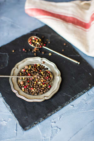 Peper grain spice on vintage plate on concrete backgroundの写真素材