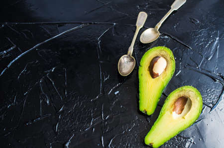 Organic avocado two pieces with vintage flatwareon rustic backgroundの写真素材