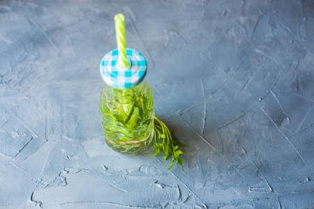 Bottle of water with rukkola herb as a organic food concetの写真素材