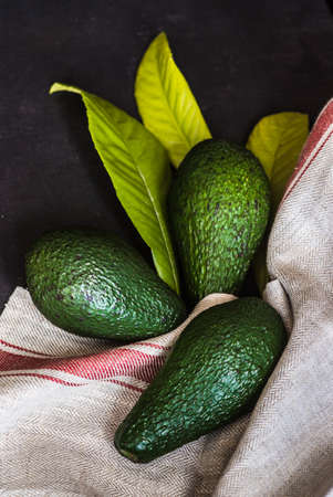Three organic avocado on rustic wooden tableの写真素材