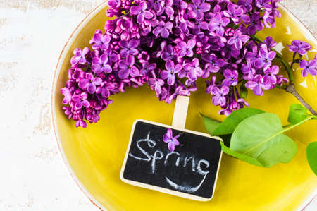 Spring table setting with bright lilac flowers on rustic background with copyspace
