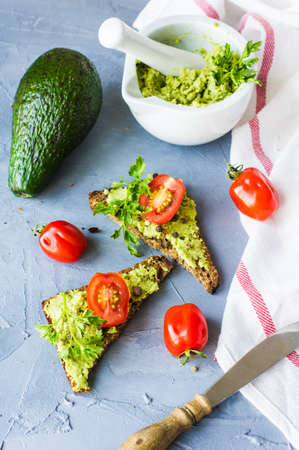 Healthy food concept with bread and avocado vegetable on natural background in rustic style