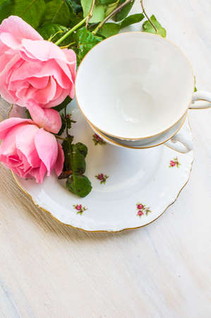 Summer festive table setting with beautiful roses and vintage flatware on dark wooden table