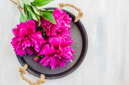 Bright purple peony flowers on rustic wooden table with copyspaceの写真素材