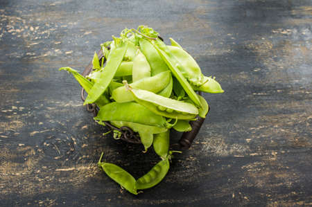 Organic green peas on rustic background