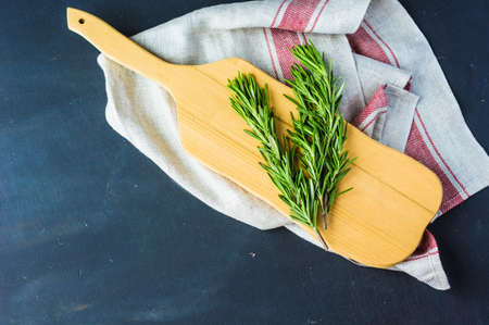 Fresh rosemary spice on dark wooden board with copyspaceの写真素材