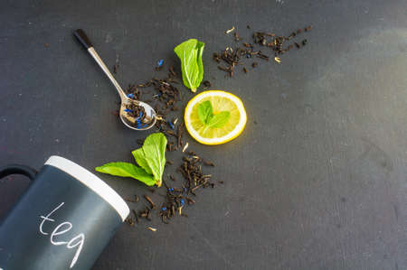Dry tea leaves with flowersand fruits on wooden background with copyspace as a organic tea conceptの写真素材