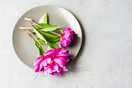 Summer festive table setting with beautiful purple peonies and vintage flatware on grey concrete background with copyspaceの写真素材