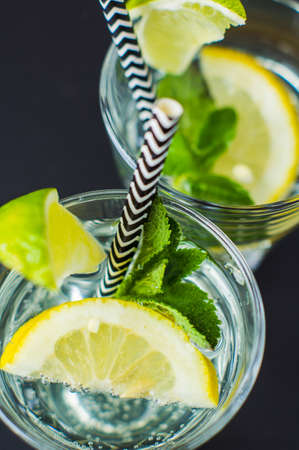 Fresh homemade detox lemonade with lime, lemon, rosemary, mint and ice on rustic wooden table with copyspaceの写真素材