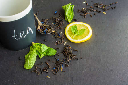Dry tea leaves with flowersand fruits on wooden background with copyspace as a organic tea conceptの写真素材