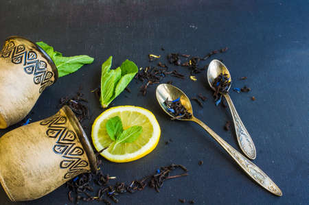 Dry tea leaves with flowersand fruits on wooden background with copyspace as a organic tea conceptの写真素材