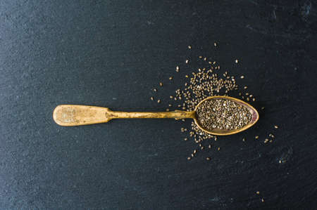 Organic chia seeds in a vintage spoon on dark wooden table with copyspaceの写真素材