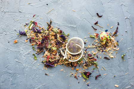 Dry tea leaves with flowersand fruits on wooden background with copyspace as a organic tea conceptの写真素材