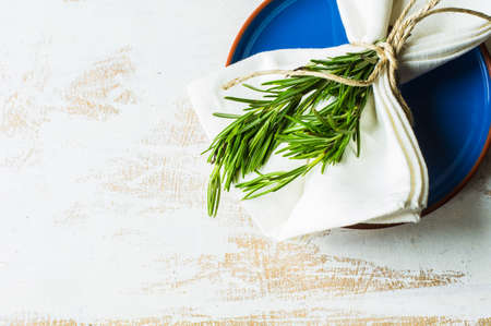 Rustic table setting with rosemary on dark wooden table with copyspaceの写真素材
