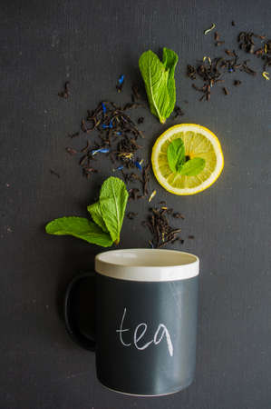 Dry tea leaves with flowersand fruits on wooden background with copyspace as a organic tea conceptの写真素材