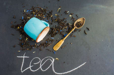Dry tea leaves with flowersand fruits on wooden background with copyspace as a organic tea conceptの写真素材
