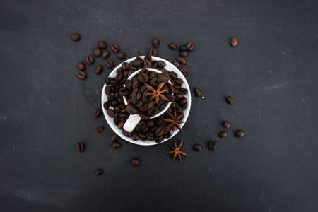 Coffee mug full of organic coffee beans on dark background with copyspaceの写真素材
