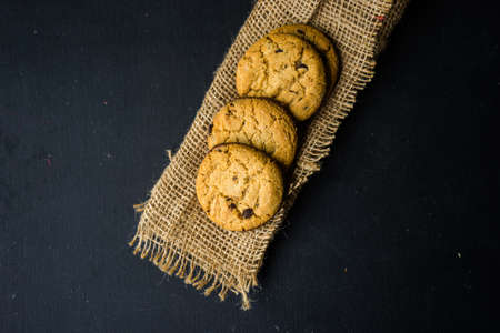 Flat lay of chocolate cookies on burlap napkin with copyspaceの写真素材
