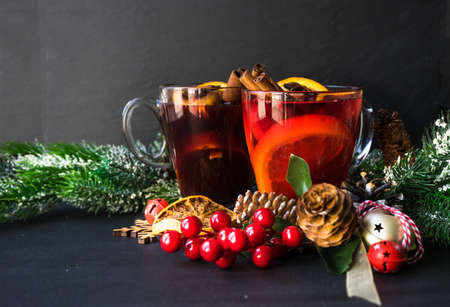 Glass od spiced mulled wine and Christmas decoration on black table with copyspaceの写真素材