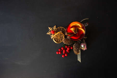 Glass od spiced mulled wine and Christmas decoration on black table with copyspaceの写真素材