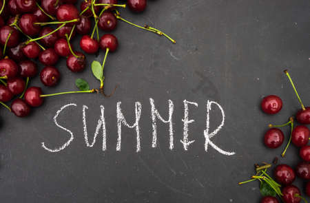 Summer consept with fresh cherry on chalkboard with copyspaceの写真素材