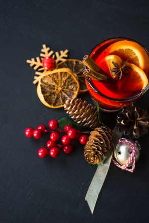 Glass od spiced mulled wine and Christmas decoration on black table with copyspaceの写真素材