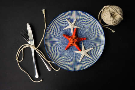 Summer vacation marine table setting with rustic plates and silverware on wooden background with copyspaceの写真素材