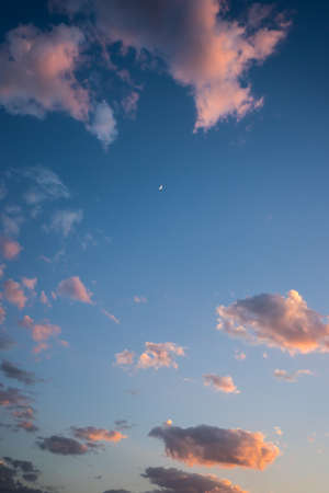 Blue sky in sunset time with clouds and moonの写真素材