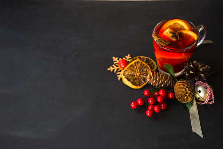 Glass od spiced mulled wine and Christmas decoration on black table with copyspaceの写真素材