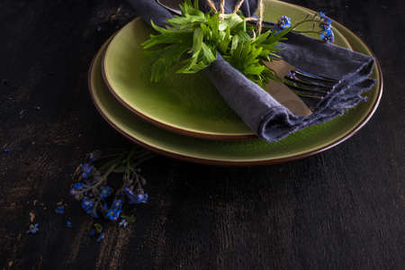 Summer floral table setting with bright blue forget-me-not flowers on wooden table