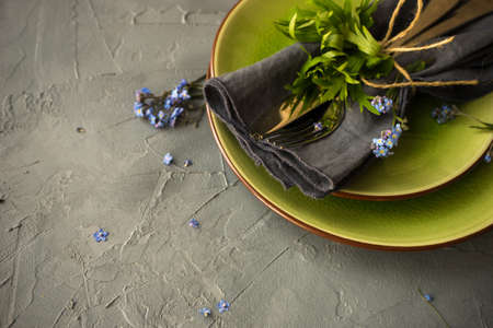 Summer floral table setting with bright blue forget-me-not flowers on wooden tableの写真素材