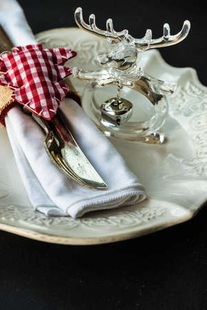 Table setting for Christmas dinner with festive decoration on dark wooden table with copyspace