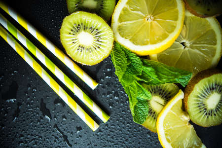 Flat lay with kiwi, lemon and mint on stone background with copyspaceの写真素材