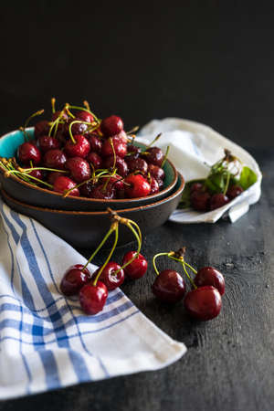 Organic food concept ripe red sweet cherries on dark wooden tableの写真素材