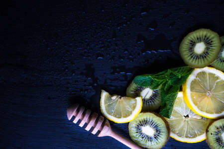 Flat lay with kiwi, lemon and mint on stone background with copyspaceの写真素材