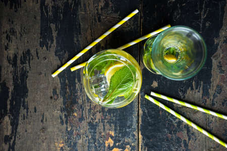 Detox drink with organic lemon and mint herb on dark wooden table with copyspaceの写真素材