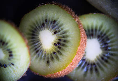 Closeup of kiwi  slices on dark wooden backgroundの写真素材