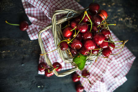 Organic food concept ripe red sweet cherries on dark wooden tableの写真素材