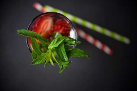Detox organic drink with strawberries, blueberries and mint on dark wooden tableの写真素材