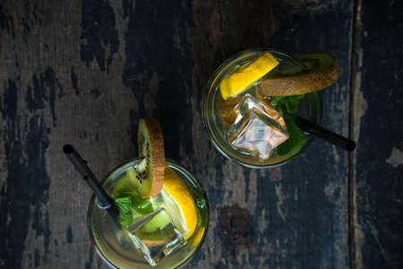 Organic food concept of fresh kiwi smoothie on grey concrete background with fruits and mintの写真素材