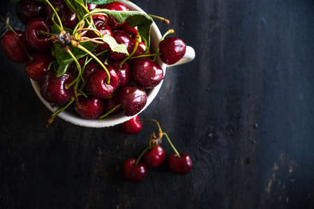 Organic food concept ripe red sweet cherries on dark wooden tableの写真素材