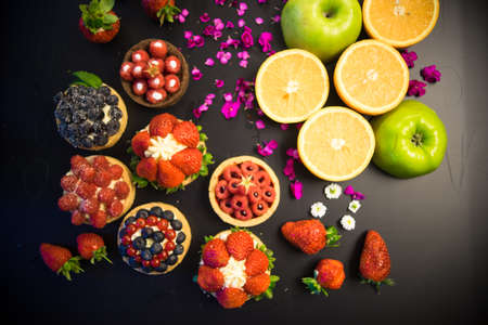 Tartlets with fresh berries on dark wooden tableの写真素材