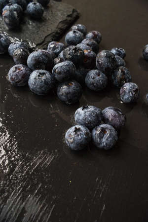 Ripe organic bilberries on dark wooden table with copyspace as a organic food conceptの写真素材