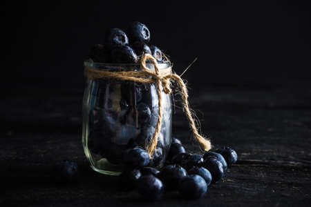 Ripe organic bilberries on dark wooden table with copyspace as a organic food concept