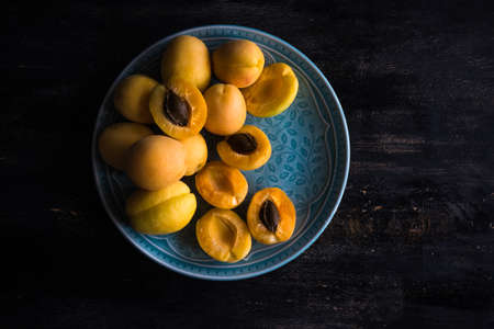 Ripe organic apricots on dark wooden table with copyspace as a organic food concept