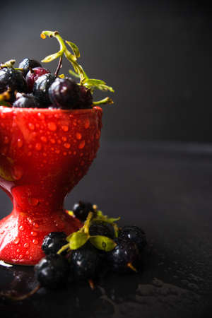 Ripe organic currant berries  on dark wooden table with copyspace as a organic food concept