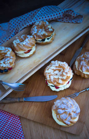 Dessert profitrole with vanila cream and ripe fresh berries like a strawberry, bilbery and rapsberryの写真素材