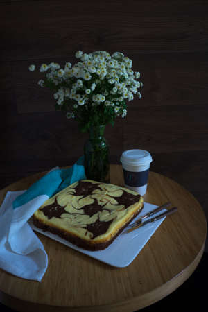 Cheese cake and flowers on the rustic tableの写真素材