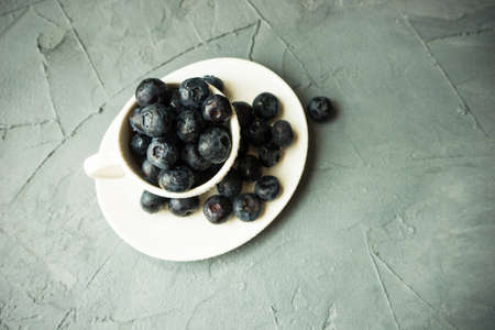 Ripe organic bilberries on dark wooden table with copyspace as a organic food conceptの写真素材
