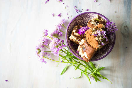 German kuchen chocolate dessert and wild summer purple flowers on a rustic white tableの写真素材